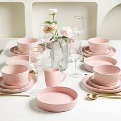 a white table topped with pink plates and cups