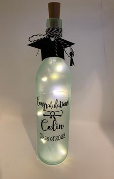 a light up bottle with a graduation cap on top