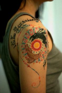 a woman's arm with tattoos on it and an image of a bird in the sky