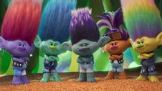 the smurfs are all lined up in front of some colorful colored hair on top of each other