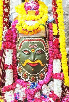 an elaborately decorated statue with flowers around it