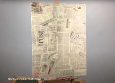 an old newspaper is hanging on the wall next to a painting easel and paintbrushes