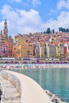 the beach is lined with colorful buildings and umbrellas in front of the water's edge