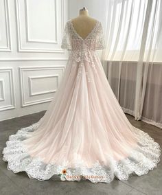 a wedding dress is displayed on a mannequin in front of a white wall