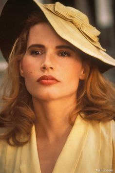 a woman wearing a yellow hat with a large bow on it's brim