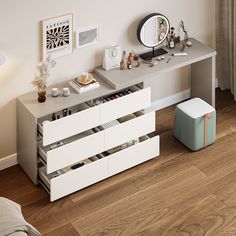 a white desk with drawers and a mirror on it's wall next to a bed