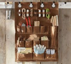 a brown bag filled with lots of items on top of a wooden floor next to scissors and toothbrushes