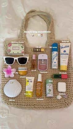 the contents of a beach bag laid out on a bed