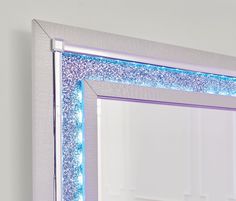 a mirror that has some lights on the edge of it and is reflecting something blue