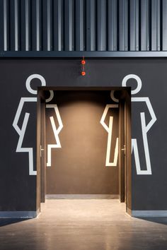 an open door leading into a restroom with men and women symbols on it