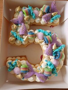 the letter e is made out of cookies and decorated with mermaid tailes, seashells, and seahorses