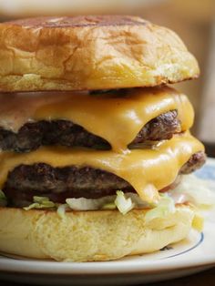 a cheeseburger on a bun with onions and ketchup is sitting on a plate