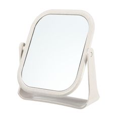 a white mirror sitting on top of a stand