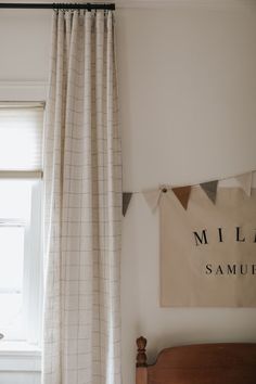 a bedroom with a bed, window and curtains