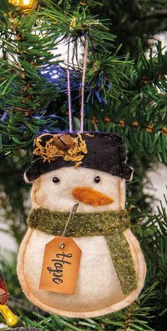 a snowman ornament hanging from a christmas tree