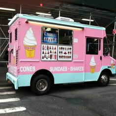 a pink and blue ice cream truck parked in a parking lot