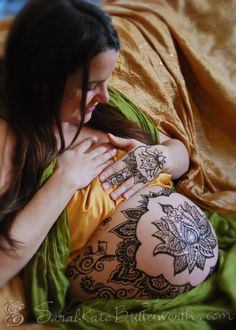 a woman laying on top of a bed covered in tattoos