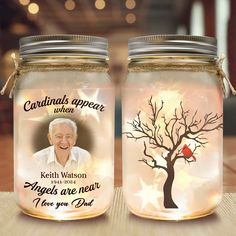 two mason jars with an image of a man and a tree on the inside one