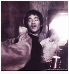 a black and white photo of a man talking on the phone while holding a beer