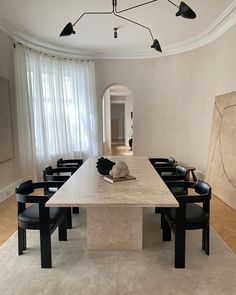 a dining room table with black chairs around it