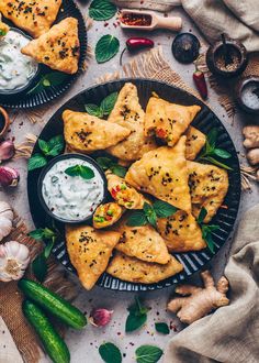 some food is sitting on a plate with sauce and herbs next to it, along with other foods