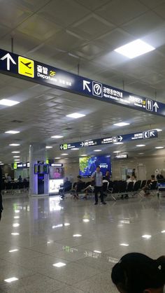 an airport terminal with people waiting for their luggage