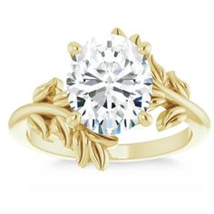 a yellow gold engagement ring with leaves on the band and a round diamond center stone