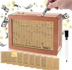 a wooden box filled with lots of money next to a pen and some sort of calculator