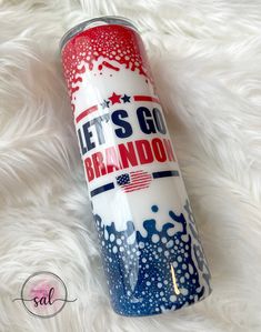 a red, white and blue water bottle sitting on top of a fluffy white blanket