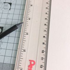 there is a ruler and a pair of scissors on the table