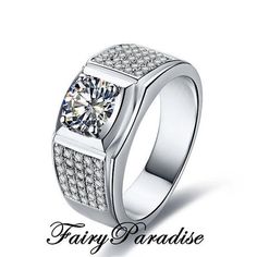 a white gold ring with diamonds on the sides and an inscription fairy paradise above it