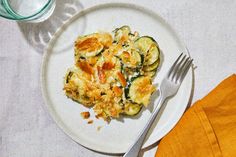 a white plate topped with an egg casserole next to a cup of coffee