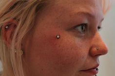 a blonde woman with piercings on her nose