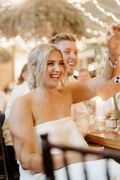 a bride and groom sitting at a dinner table