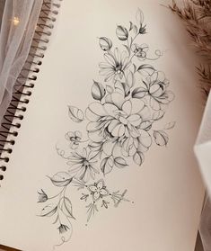 a drawing of flowers on paper next to a pen and pencil sharpener, with tulle