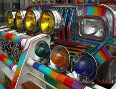 many different colored lights are on top of each other in front of a car that is painted multicolored