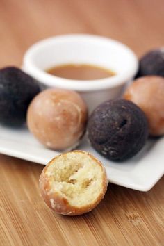 three donuts on a plate with dipping sauce