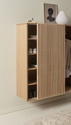 a wooden cabinet sitting on top of a carpeted floor next to a white wall