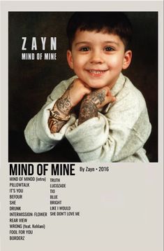 a young boy with tattoos on his arms and chest smiling at the camera, in front of a black background