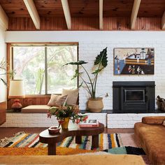 a living room filled with furniture and a fire place in front of a brick wall