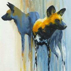 two wild dogs standing next to each other in front of a blue and yellow background