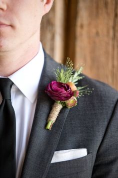 a man in a suit and tie with a boutonniere on his lapel