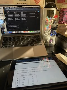 an open laptop computer sitting on top of a desk next to a calculator