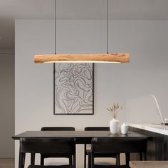 a dining room table with four chairs and a wooden beam hanging from the ceiling