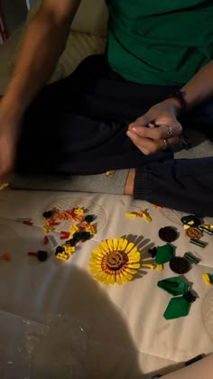 a person sitting on the floor with legos all over their feet and hands together