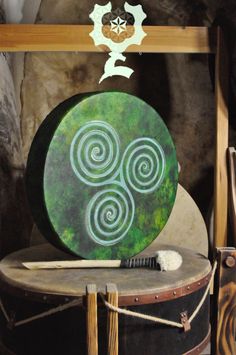 a wooden drum sitting on top of a table next to a green and white sign