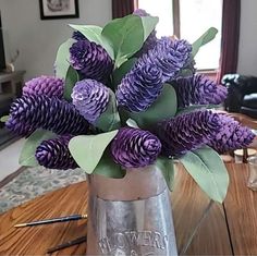 purple flowers are in a glass vase on the table