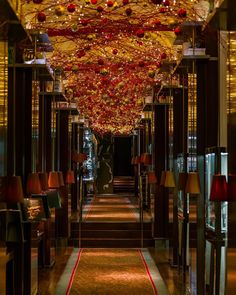 the hallway is decorated with red and gold ornaments hanging from the ceiling, along with lamps on either side