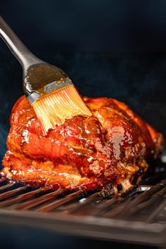 a bbq chicken being cooked with a brush