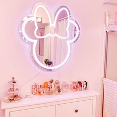 a mirror that is on top of a dresser next to a shelf with makeup and other items